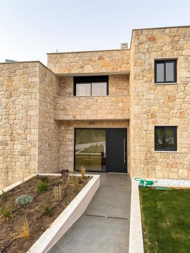 a stone house with a black door at The Olive Path in Kalandra