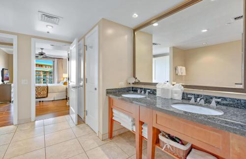 a bathroom with two sinks and a large mirror at Honua Kai Resort And Spa By Maui Resort Rentals in Lahaina