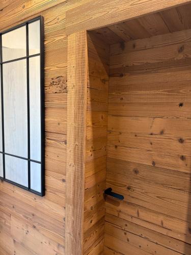 a room with wooden walls and a window at Apartment Orol view of the Tatras with a private sauna in Svit