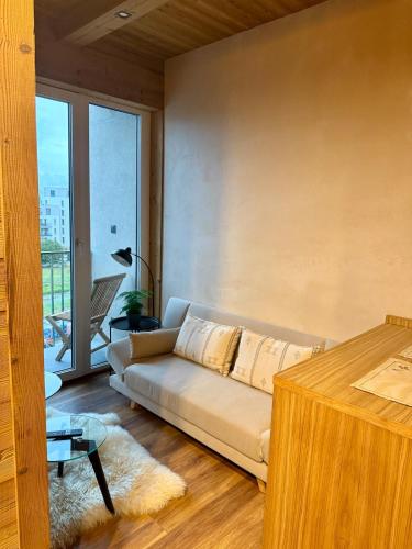 a living room with a couch and a large window at Apartment Orol view of the Tatras with a private sauna in Svit