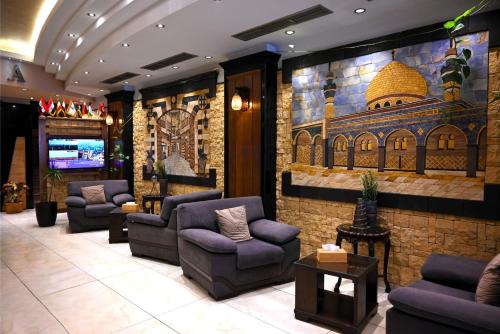 a lobby with chairs and a painting of a mosque at BARADA Hotel- فندق بردى in Qaryat al Bulush