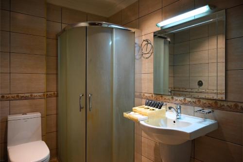a bathroom with a toilet and a sink and a mirror at BARADA Hotel- فندق بردى in Qaryat al Bulush