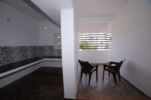 two black chairs in a room with a window at The Base Residency in Puducherry