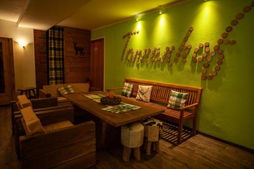 a living room with a table and a green wall at Landhotel Tannenhof in Spiegelau