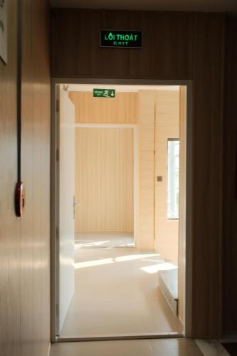 a door leading into a hallway with a sign on it at Alphan Hotel in Vạn Ninh