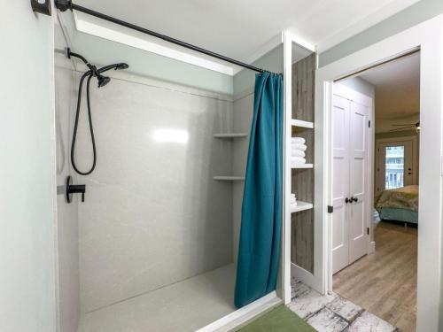 a shower with a blue shower curtain in a bathroom at Sea Oats B106 by ALBVR - Pet Friendly - Great renovation and tons of space in this condo - Outdoor Pools, Pier, and Dedicated Beach Access in Gulf Shores
