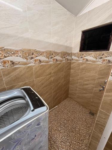 baño con lavadora y TV en Homestay Pendang, en Pendang