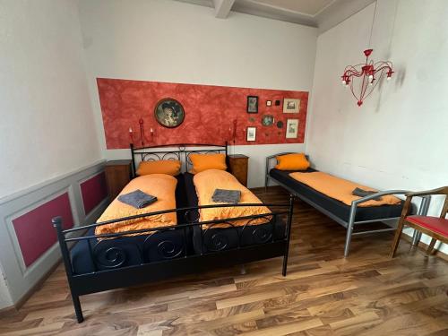 a bedroom with two beds with orange pillows at Pension Jeske Heidelberg in Heidelberg