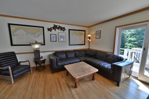 a living room with a leather couch and a chair at Farmhouse in Hershey in Hershey