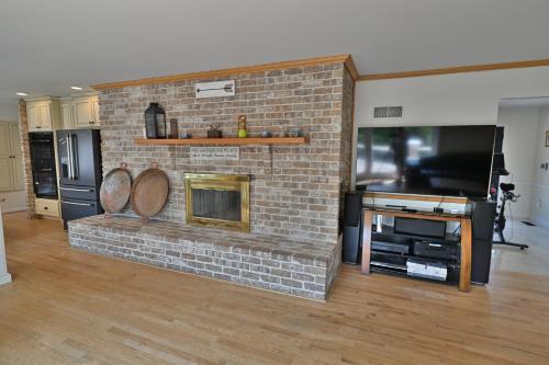 a brick fireplace in a living room with a tv at Farmhouse in Hershey in Hershey