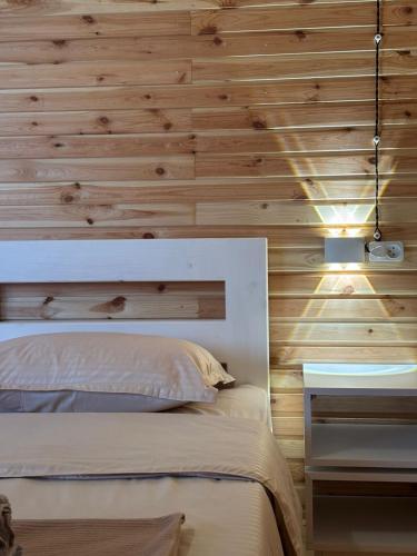 a bedroom with a bed and a wooden wall at Eco-friendly Guesthouse Tea Gezruli 25 km from Chiatura in Tsinsopʼeli