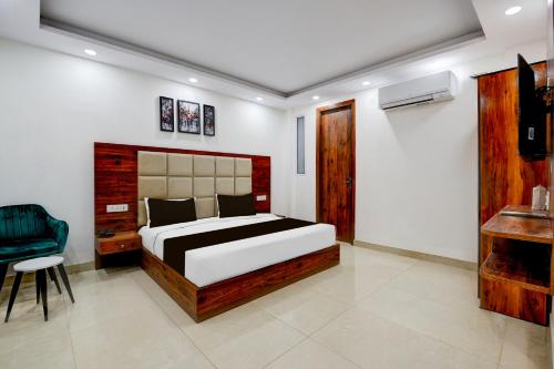 a bedroom with a bed and a chair in it at Super Collection O Hotel Evergreen in Faridabad