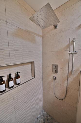 a bathroom with a shower with two bottles of soap at Farmhouse in Hershey in Hershey