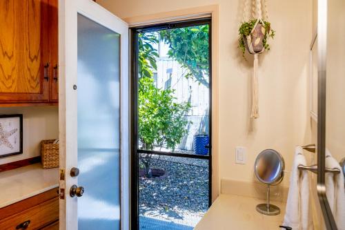 a bathroom with a door leading to a yard at Seaside Garden Escape, A Stroll to the Beach! in Grover Beach