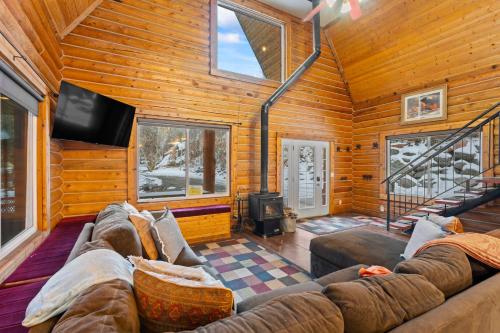 a living room with a couch and a tv at Evy's Family Ranch Cabin Secluded in Heber City