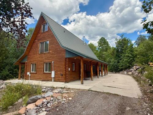 a large wooden cabin with a gambrel roof at Evy's Family Ranch Cabin Secluded in Heber City