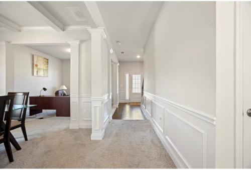 a hallway with white walls and a table and chairs at Conyers Place in Conyers