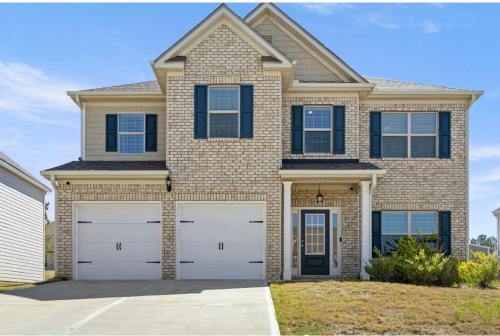 a house with two garage doors in front of it at Conyers Place in Conyers