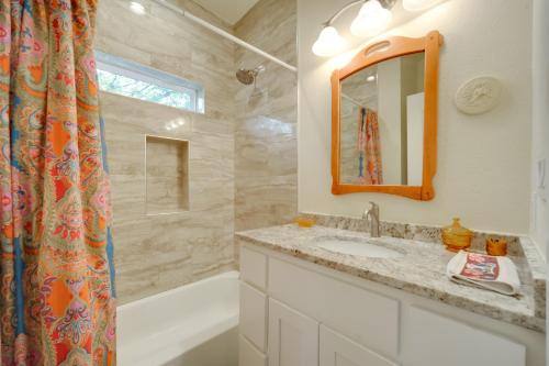 a bathroom with a sink and a mirror and a tub at Cozy Casita and Cabana on Lake Marble Falls! in Cottonwood Shores
