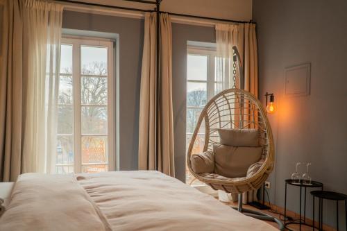 a bedroom with a wicker chair in front of a window at Albergo-Toscana in Bad Schandau