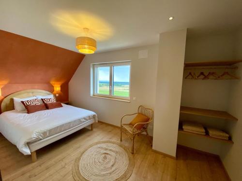 a bedroom with a large bed and a window at L'horizon des vignes in Itterswiller