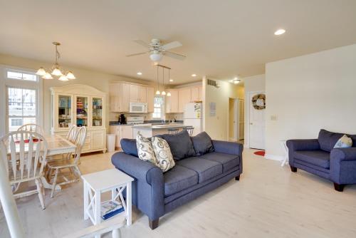 a living room with a blue couch and a kitchen at Sunny Ocean City Retreat about Qtr-Mi to Beach! in Ocean City