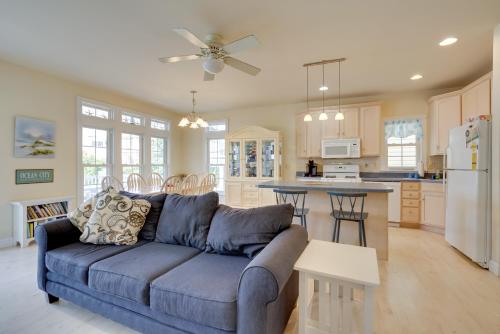 a living room with a blue couch and a kitchen at Sunny Ocean City Retreat about Qtr-Mi to Beach! in Ocean City