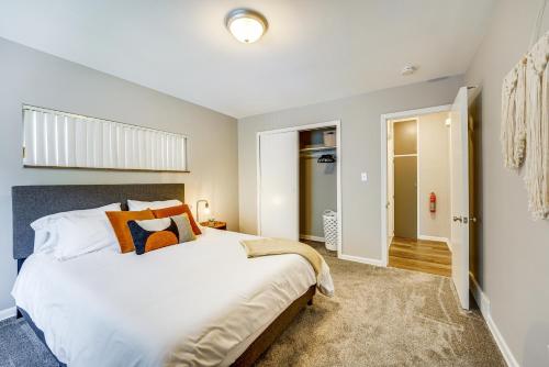 a bedroom with a large white bed with orange pillows at Pet-Friendly Wyandotte Apt Near Bishop Park! in Wyandotte