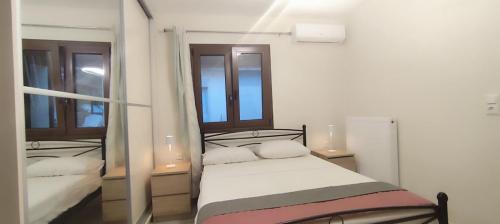1 dormitorio con 1 cama y 2 espejos en Δίκταμο, en Mouzákion