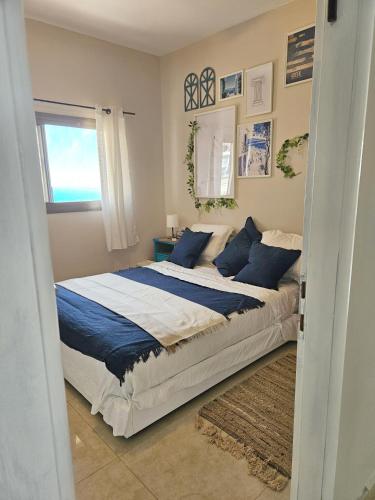 a bedroom with a large bed with blue pillows at Beachfront Bliss 3 bedroom Privacy in Netanya
