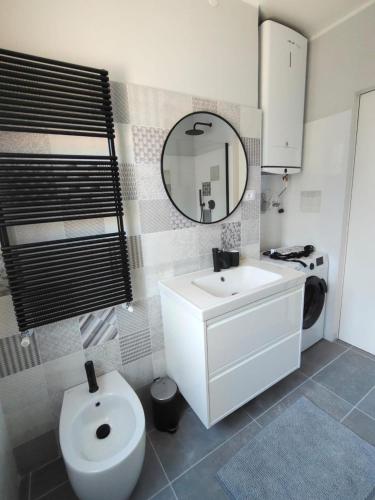 a bathroom with a sink and a toilet and a mirror at Petit Brunò in Monfalcone