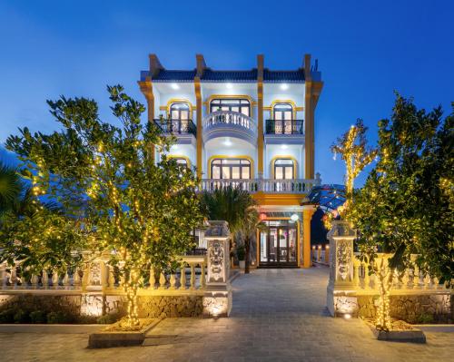 a large white building with trees in front of it at Tam Coc Babylon Hotel in Ninh Binh