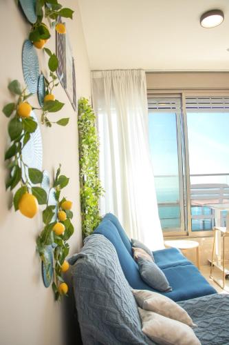 a living room with a blue couch and a window at Beachfront Bliss 3 bedroom Privacy in Netanya