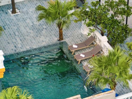 an overhead view of a swimming pool with chairs and palm trees at Tam Coc Babylon Hotel in Ninh Binh