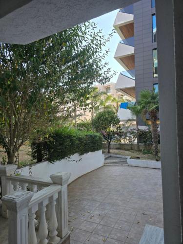 a balcony with a white railing and a building at Alpha 2 Rooms in Sarandë