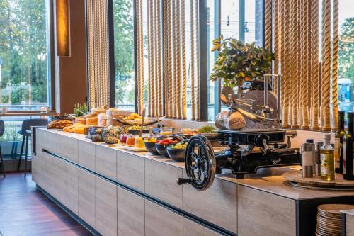 a buffet line with food on a counter with an old fashioned at ScanHotels City in Rostock