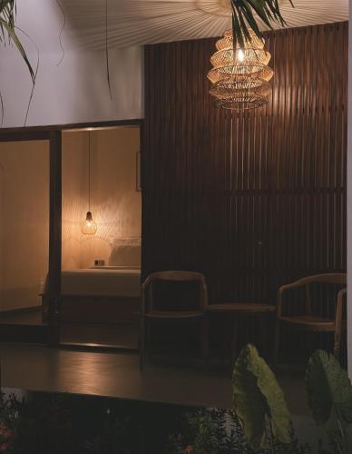 a room with a bed and a chandelier at Tropical Almond Villa in Uluwatu