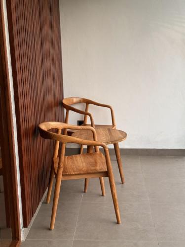 a wooden chair sitting next to a wall at Tropical Almond Villa in Uluwatu