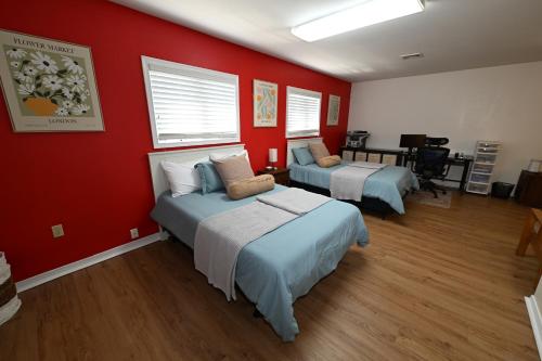 two beds in a room with red walls at Farmhouse in Hershey in Hershey