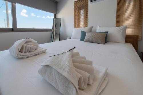 a bedroom with a large white bed with towels on it at LIVAS Residence in Tympáki