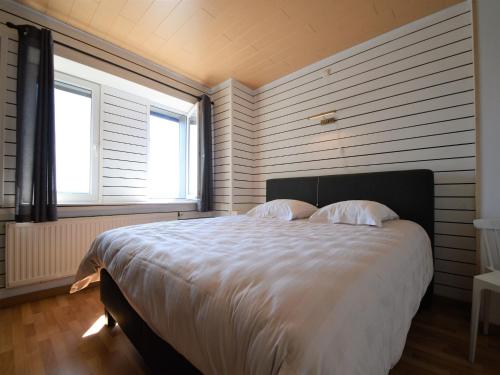 a bedroom with a large white bed with two pillows at Rochehaut Hideaway with Tub in Rochehaut