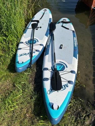 two kayaks sitting on the grass next to the water at Direkt am See mit privatem Sandstrand in Güster