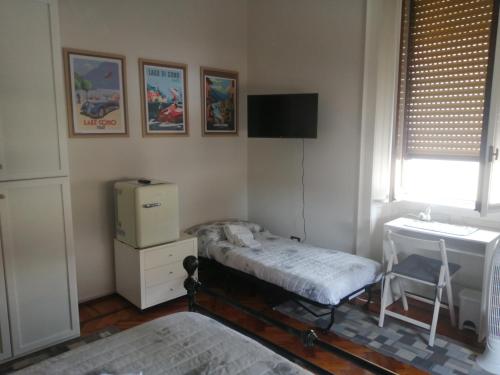 a room with a bed and a desk and a tv at Camera con bagno PVT e aree relax in Mariano Comense