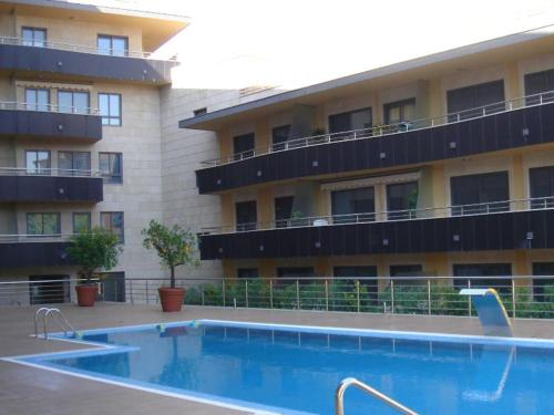 um hotel com piscina em frente a um edifício em Playa Sanxenxo em Sanxenxo