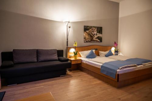 a bedroom with a bed and a couch at Landhotel Tannenhof in Spiegelau