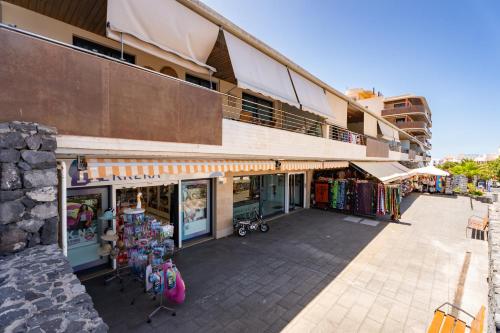 a store with tables and chairs in front of a building at El Teide in Puerto de Santiago