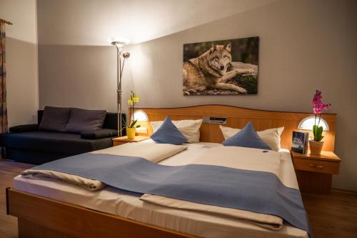 a bedroom with a large bed with a wolf picture on the wall at Landhotel Tannenhof in Spiegelau