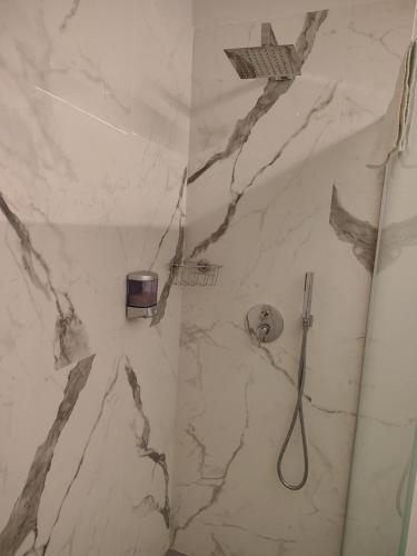 a bathroom with a shower with a white marble wall at Oasis Apartment - Pontassieve Guest House 2 - 20 minuti da Firenze in Pontassieve