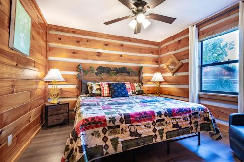 a bedroom with a bed in a room with wooden walls at Views, King & Sofa Bed, Hot Tub, Firepit And Deck in Sevierville