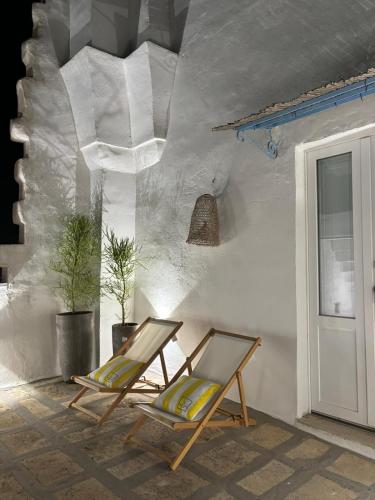 two chairs sitting in a room with a wall at L’Edicola Votiva in Casarano